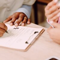 「親の介護 相談」をする家族とケアマネージャーが話し合う様子。介護の悩みを解決するための相談風景。