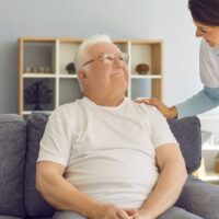 介護でおむつ交換がきついと感じている女性が夜中にため息をつく様子