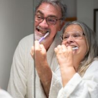 口腔ケアを始める前に高齢者へ笑顔で声をかける介護者